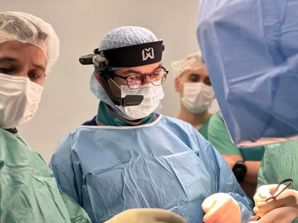 Professor Al Muderis operating, wearing a surgical headset